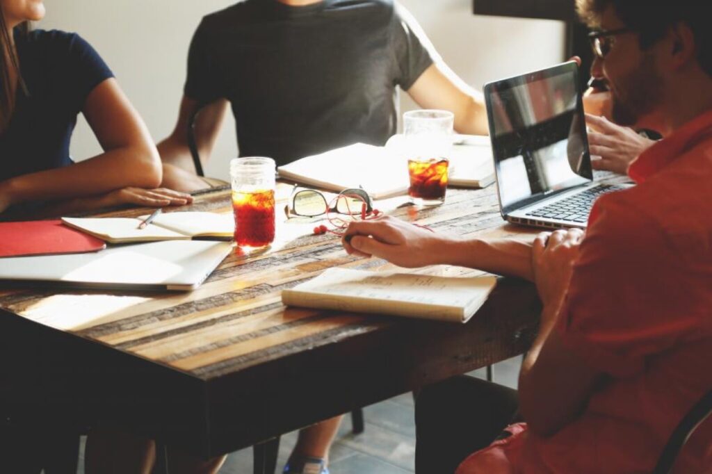Startup team working together around a table with a laptop